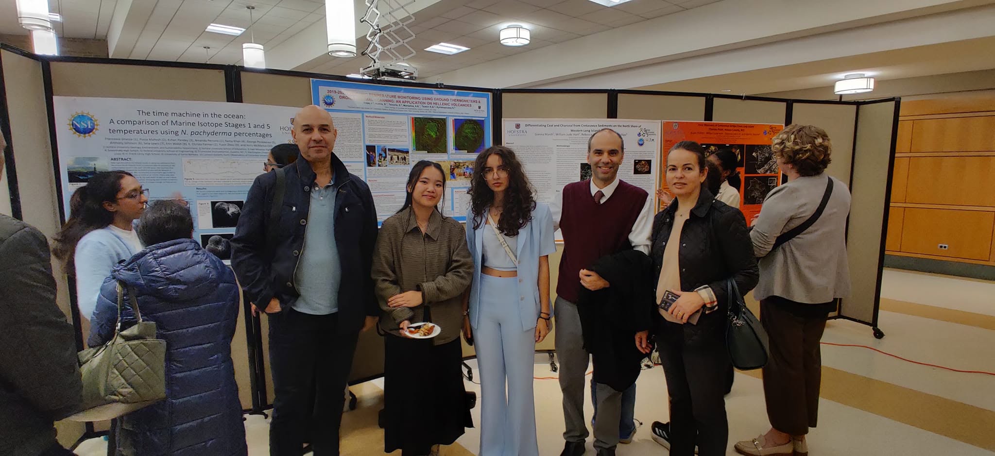 Dr. Marsellos with student researchers and visitors at a conference poster session